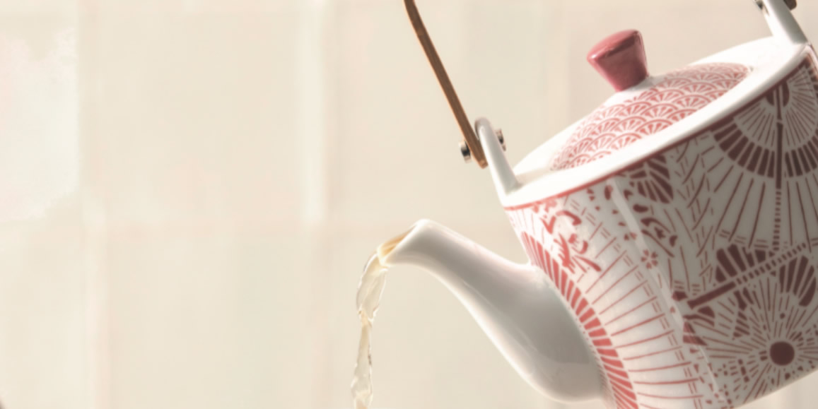 Porcelain teapot pours out tea